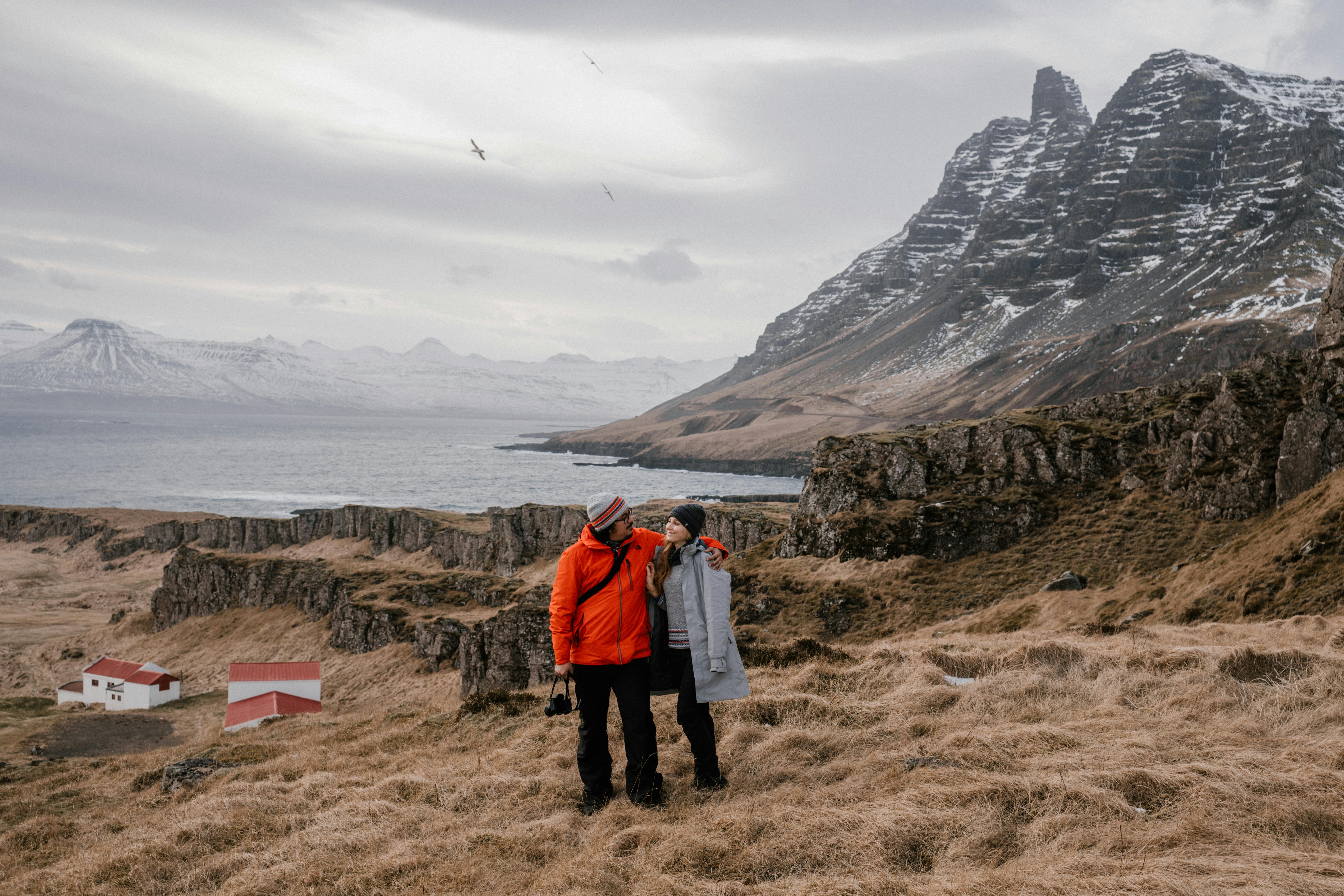 A couple embraces in a dramatic Icelandic landscape, showcasing love and adventure.